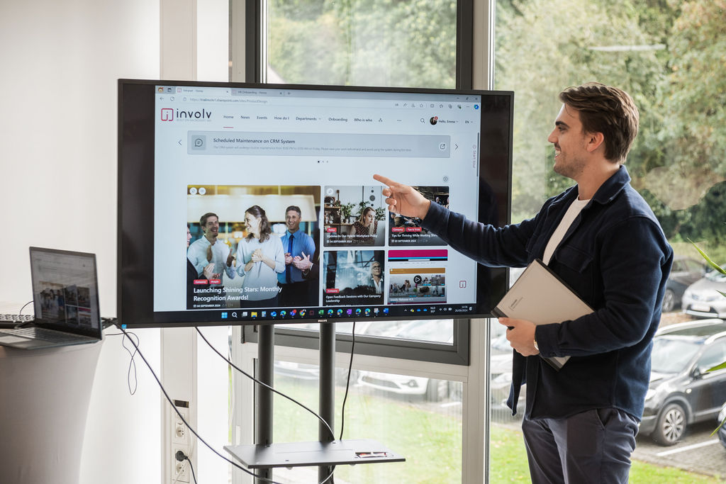 An Involv colleague demonstrates the Involv intranet on a screen